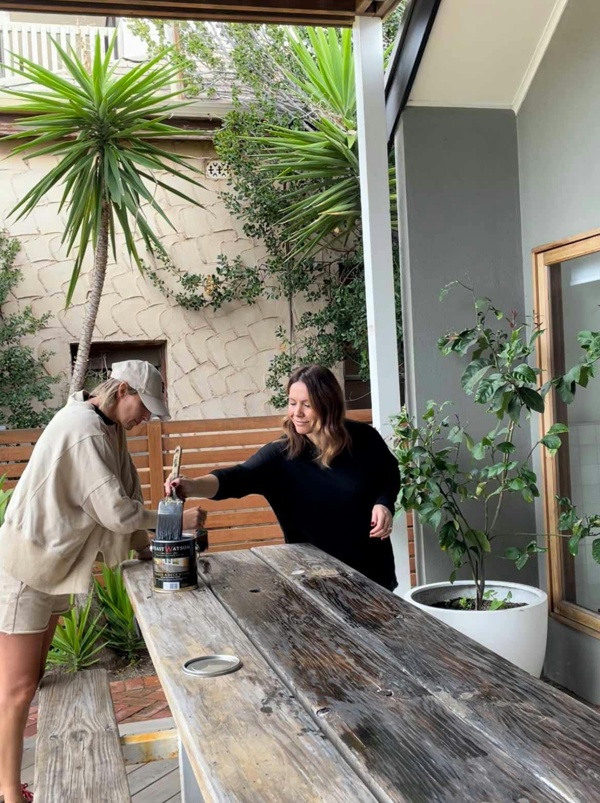 The Style Hosts applying Timber & Deck Stain on an outdoor timber table